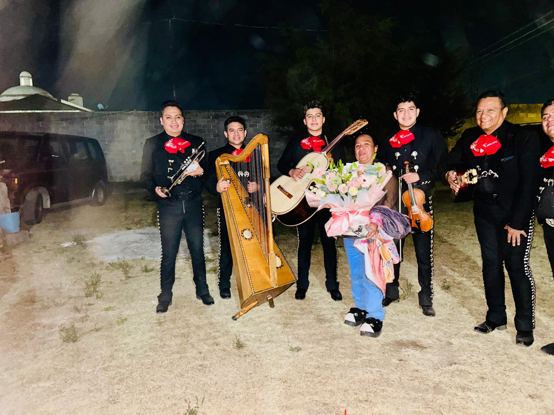Mariachi entregando flores en una serenata nocturna